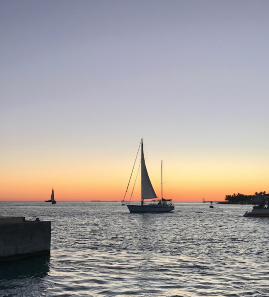 sailboats with sunset in the background