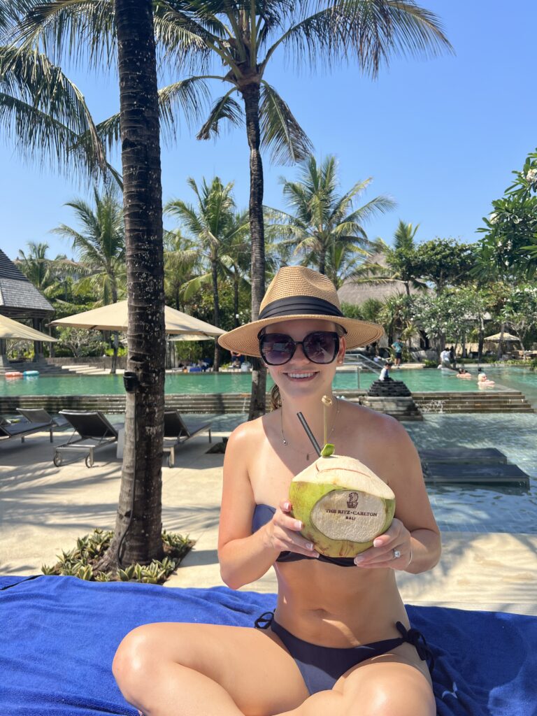 overlooking the pool from our pool cabana and me with a coconut