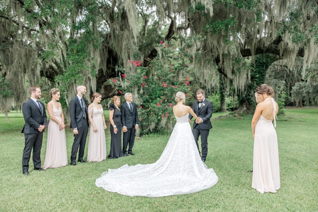 first look with full family admiring wedding dress and bride